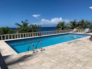 a swimming pool with the ocean in the background at Oceanfront 3 bedrooms, 4beds, AC, WiFi, luxury villa in Woodlands