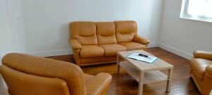 een woonkamer met 2 stoelen en een tafel bij Chez J&F in Elbeuf
