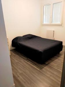 a black bed in a room with a window at Appartement en duplex au 3ième étage sans ascenseur in Hyères
