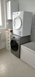 een magnetron bovenop een wasmachine in een keuken bij Chez J&F in Elbeuf