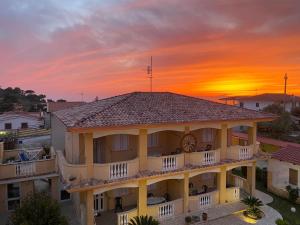 a building with a sunset in the background at Villettemire in Capo Vaticano