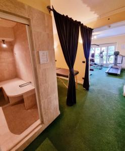 Habitación con baño con ducha y alfombra verde. en Hotel Canali, Portofino Coast, en Rapallo