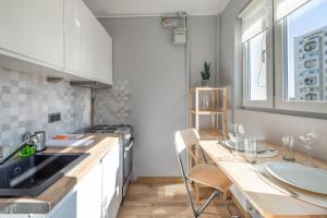 cocina con armarios blancos y encimera de madera en AP Apartments Kołobrzeska en Gdansk