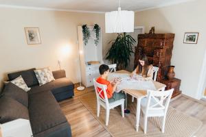 zwei Kinder, die an einem Tisch im Wohnzimmer sitzen in der Unterkunft Lilibet Guesthouse - Lilibet Vendégház in Ciumani