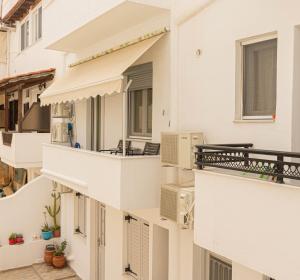 un edificio de apartamentos blanco con balcones y ventanas en Foivos Apartment, en Naxos Chora