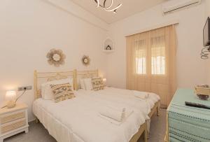 Un dormitorio blanco con una cama grande y una ventana en Foivos Apartment, en Naxos Chora