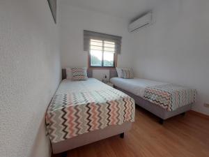 1 dormitorio con 2 camas y ventana en Vitoria Douro, en Vila Nova de Gaia