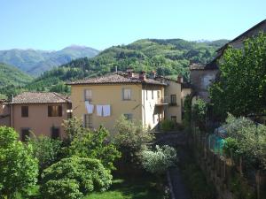 un groupe de maisons sur une colline avec des montagnes en arrière-plan dans l'établissement Nel Cielo... di Barga, à Barga