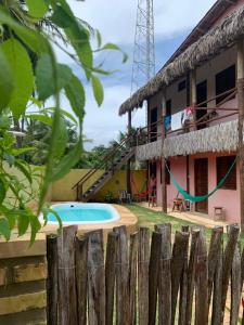 une maison avec une piscine à côté d'une clôture dans l'établissement Flat Moitas - Sua casa na praia!, à Praia de Moitas