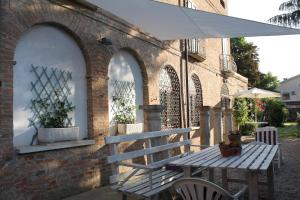 - une table de pique-nique et un parasol à côté d'un bâtiment en briques dans l'établissement B&B La Torre a Revere, à Revere