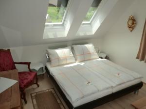 a bedroom with a bed and a chair and two windows at Exklusive Ferienwohnung / STAINZ / Luxury holiday Apartment in Stainz
