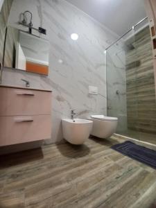 y baño con lavabo, aseo y ducha. en Villa Olympia, en Durrës