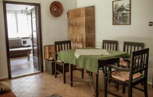 Ildikó Vendégház في Magyarszombatfa: غرفة طعام مع طاولة خضراء وكراسي