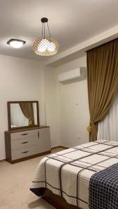 una camera con letto, cassettiera e specchio di Atallah Hotel Apartments a Città del 6 ottobre