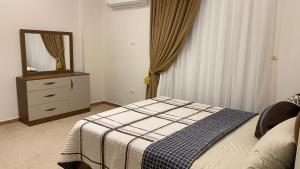 una camera con letto e comò con specchio di Atallah Hotel Apartments a Città del 6 ottobre