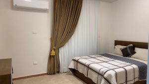 una camera con letto e finestra con tende di Atallah Hotel Apartments a Città del 6 ottobre