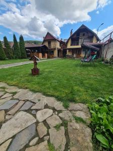 a yard with a statue in front of a house at Pensiunea Otilia in Sighişoara
