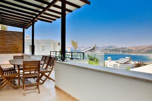 a balcony with a table and chairs and a view of the water at Villa Manzara by Important Group Travel in Bitez