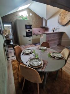 una cocina con una mesa con platos y vasos. en La Canopée en Cholet