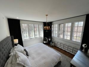 a bedroom with a white bed and windows at The Jane Toronto in Toronto