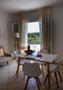 sala de estar con mesa, sillas y ventana en Il Lentischio, en Cala Gonone