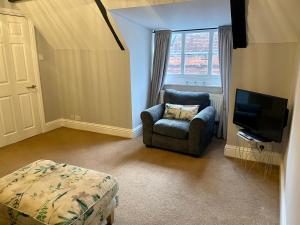 a living room with a chair and a television at Elizabeth Clark in Manningtree