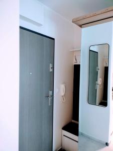 La salle de bains est pourvue d'une porte en verre et d'un miroir. dans l'établissement Apartament Zacisze OLO, à Niechorze
