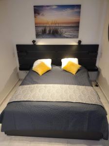 - une chambre avec un grand lit et 2 oreillers jaunes dans l'établissement Apartament Zacisze OLO, à Niechorze