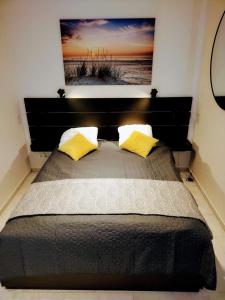 - un lit avec 2 oreillers jaunes dans une chambre dans l'établissement Apartament Zacisze OLO, à Niechorze