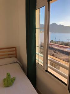 1 dormitorio con ventana y vistas al océano en Apartamento junto la playa, en Gran Tarajal