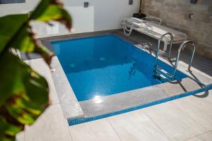 einen Pool mit blauem Wasser in einem Zimmer in der Unterkunft Thronos Aqua Appartment 1 in Pachia Ammos