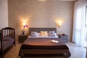 a bedroom with a large bed and a crib at Il Lentischio holiday home in Cala Gonone