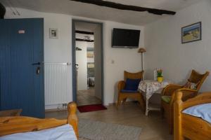 a room with a bed and a table and a television at Villa Velo in Eschwege