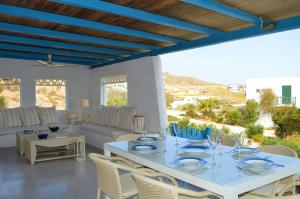 a living room with a white table and chairs at Seas the day in Mýkonos City