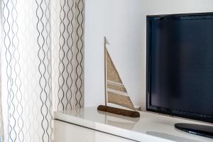 telewizor siedzący na stole z zabawką na łodzi w obiekcie LXR La Carihuela Sea Views 3HAB w mieście Torremolinos