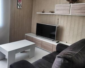 salon z kanapą i telewizorem w obiekcie A Revoltosa w mieście Laxe