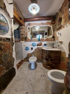 a stone bathroom with a toilet and a sink at Villetta Blu in Rio nellʼElba