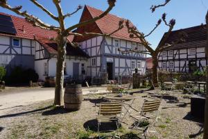 un patio con sillas, mesa y árboles en Villa Velo, en Eschwege