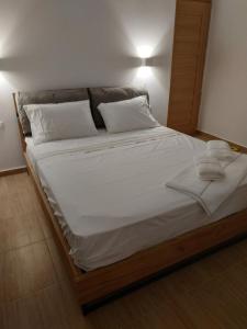 a large bed with white sheets and pillows on it at Enalion residences in Tinos Town