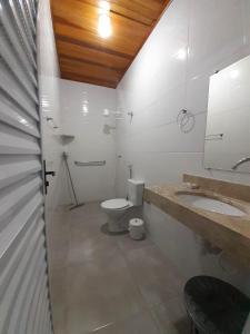 a bathroom with a toilet and a sink and a mirror at A VER O MAR FLATS in Caraguatatuba