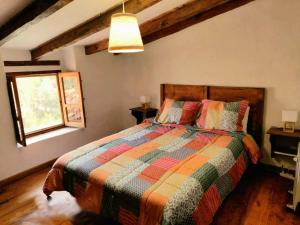 Un dormitorio con una cama con un edredón colorido y una ventana en Casa los chaparrales, en Los Anchos