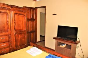a bedroom with a bed and a television and a dresser at Kalimera (Buenos Días) in Yala