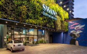 Swan Generation Porto Alegre في بورتو أليغري: سيارة متوقفة أمام مبنى به نباتات