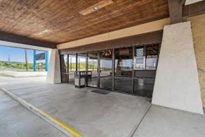 an empty building with glass windows and a wooden ceiling at OYO Hotel Junction TX I-10 in Junction