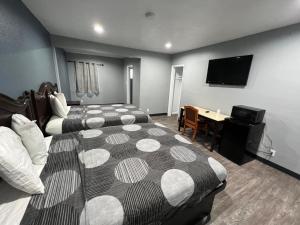 a hotel room with two beds and a desk and a television at Cornett Motel in Los Angeles