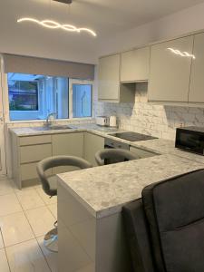 a kitchen with white cabinets and a counter with chairs at Stonehaven in Kilkenny
