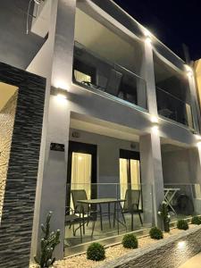 a house with a table on the balcony at night at ELITE LUXURY APARTMENTS in Argostoli