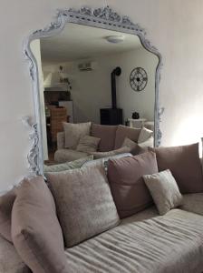 un grande specchio sopra un divano in soggiorno di Casa Vacanze Marinella a Marinella di Selinunte
