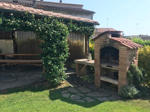 einen Garten mit einem Steinofen und einem Zaun in der Unterkunft Casa Dani con piscina privata in Monticiano