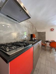Casa Foria Holiday Home Naples في نابولي: مطبخ مع موقد احمر فرن علوي